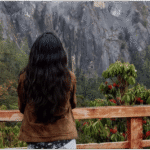 The Queen of the Hills: Rhododendron Tales from Darjeeling Blooming rhododendron tree with red flowers in Darjeeling, framed by Himalayan forest and colorful prayer flags